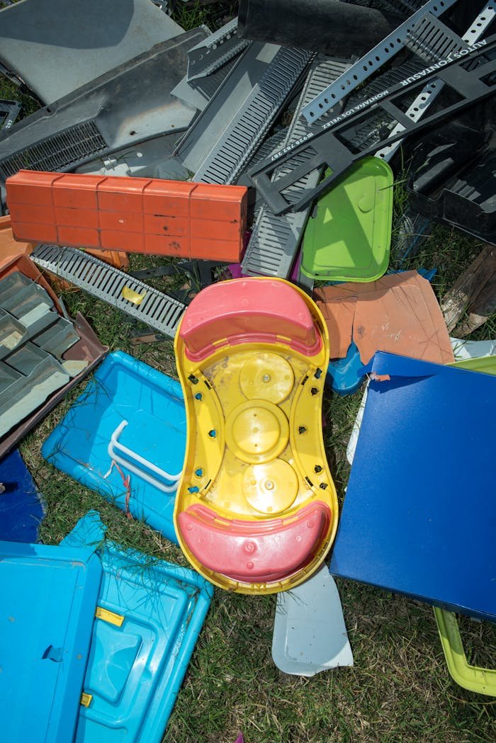 Top view of colorful plastic toys and items among various recycling materials.